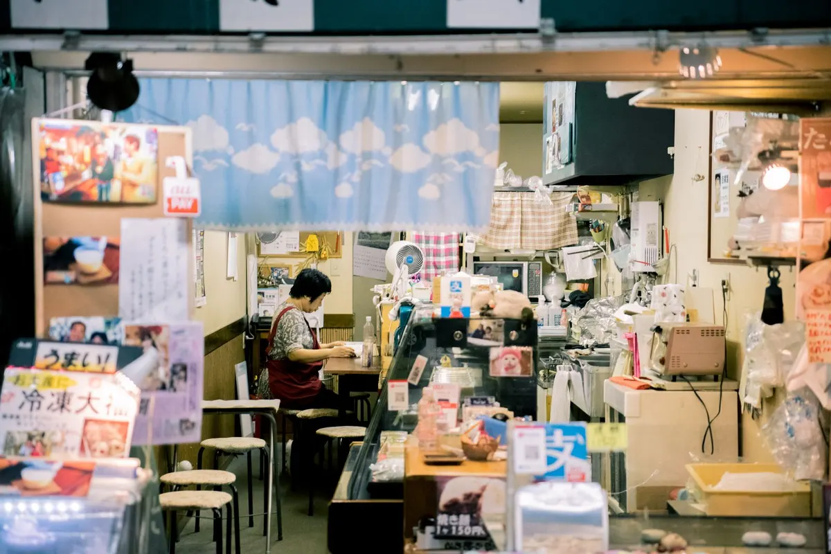 小さな飲食店の店内で働く店主のイメージ